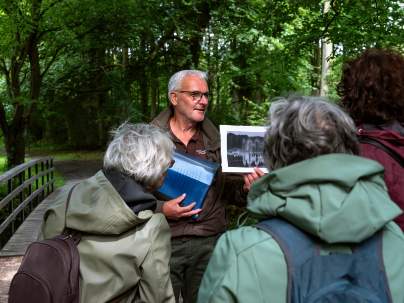 Henk Kruit, vrijwilliger bij Staatsbosbeheer, leidt een groepje belangstellenden rond door het Haagse Bos, 2024. Fotograaf Pippilotta Yerna