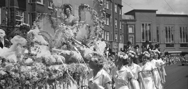 1953, Rijtoer van de bloemenkoningin mejuffrouw Tony Hulstede bij de start van de z.g. Bloemenweek. De stoet met de praalwagen in de Vondelstraat. Op de achtergrond het gebouw van de openbare bibliotheek | Fotopersbureau van den Heuvel 1953, Rijtoer van de bloemenkoningin mejuffrouw Tony Hulstede bij de start van de z.g. Bloemenweek. De stoet met de praalwagen in de Vondelstraat. Op de achtergrond het gebouw van de openbare bibliotheek | Fotopersbureau van den Heuvel