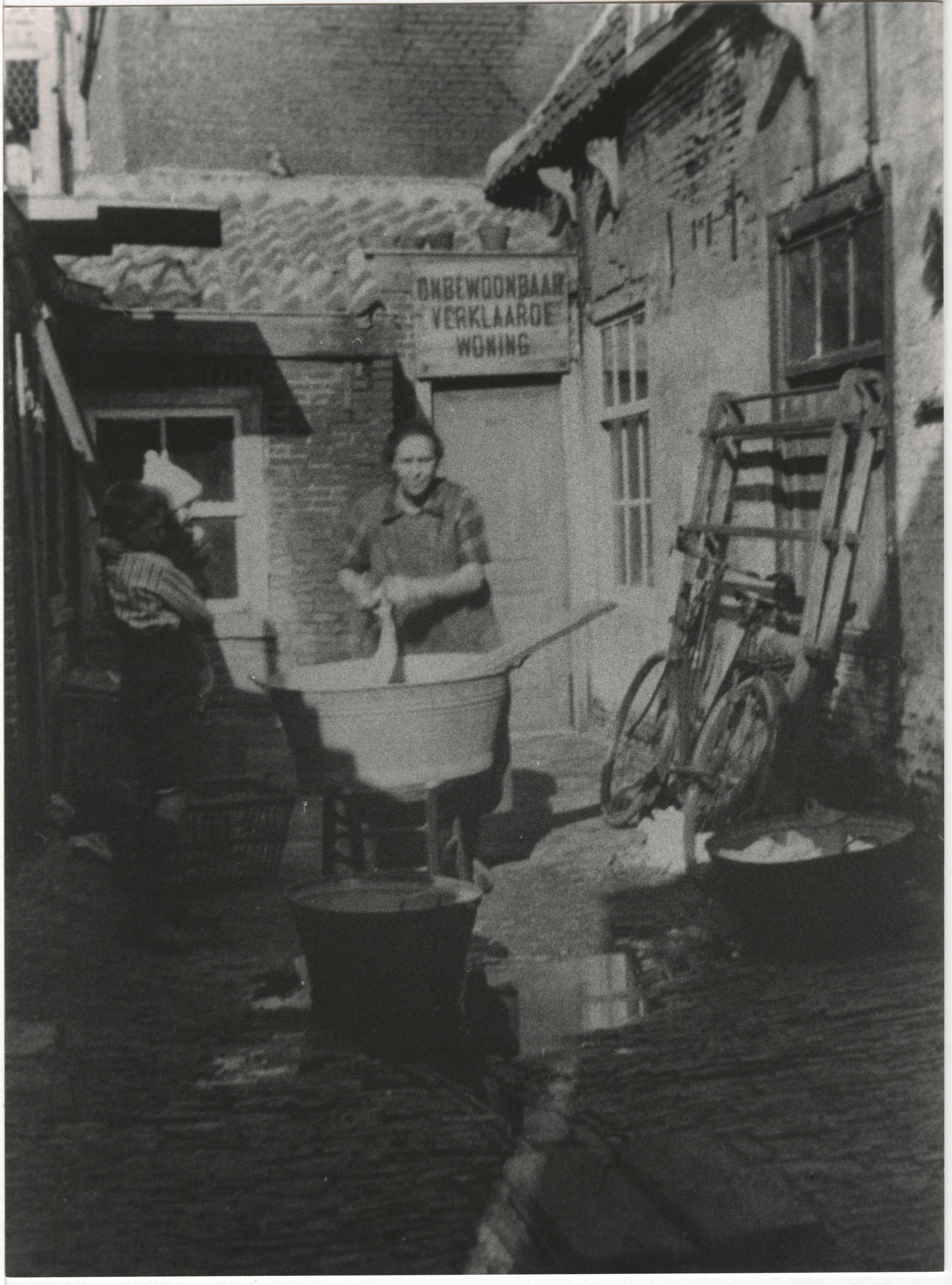 Wassenaarsestraat, een slopje waar een vrouw de was doet, 1920. Maker onbekend.