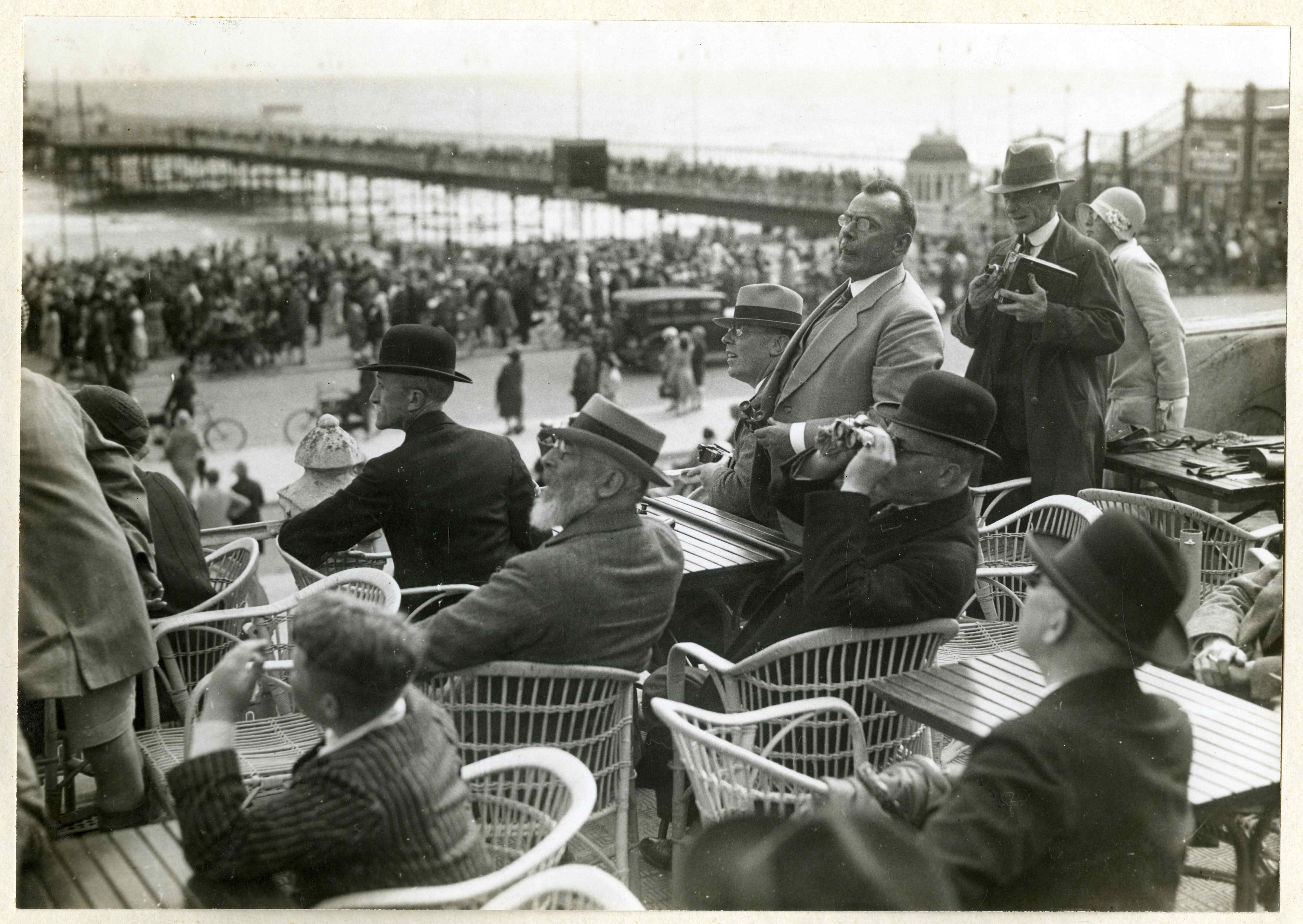 Regenproeven van de heer Veraart op het Kurhausterras te Scheveningen: met burgemeester Patijn, wethouders v.d. Meulen en Quant. Foto: 1930, maker onbekend