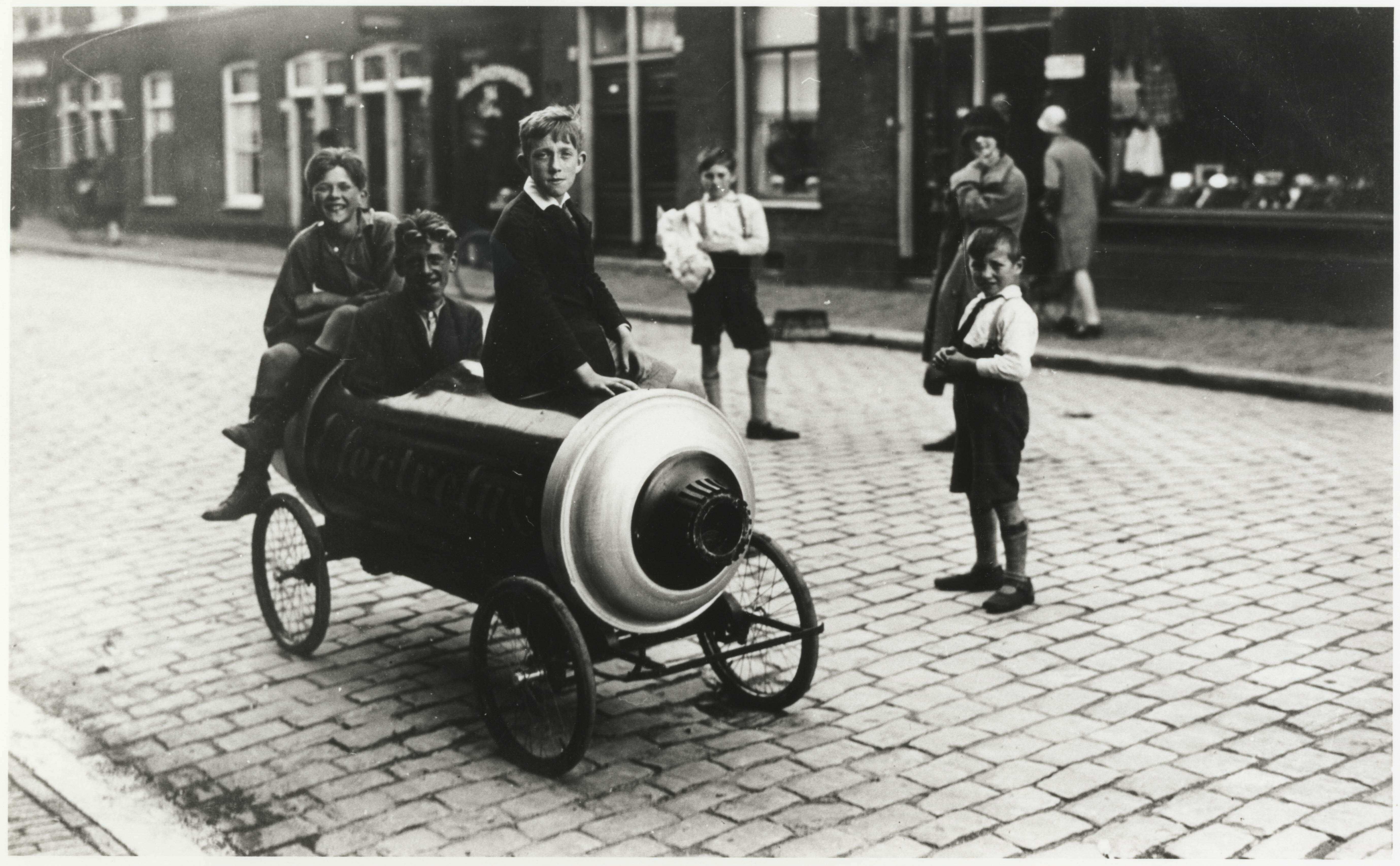 Twentstraat, drie jongens in een 'rijdende stofzuiger' (reclameobject van Electrolux), 1924