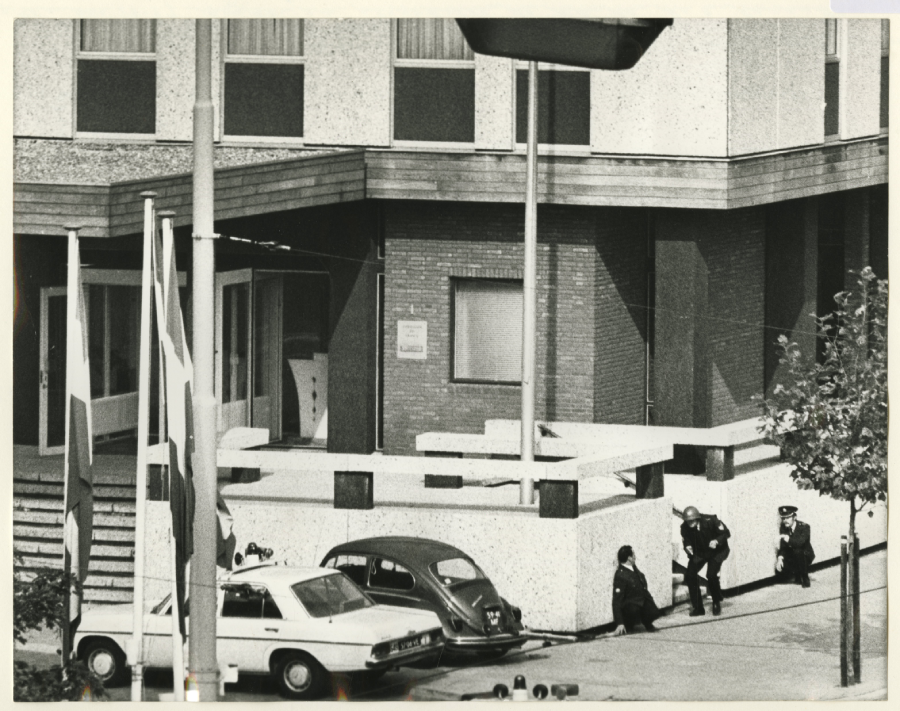 Politiemannen houden van verschillende kanten de ambassade in het oog, 1974, maker Fotoburo Meyer