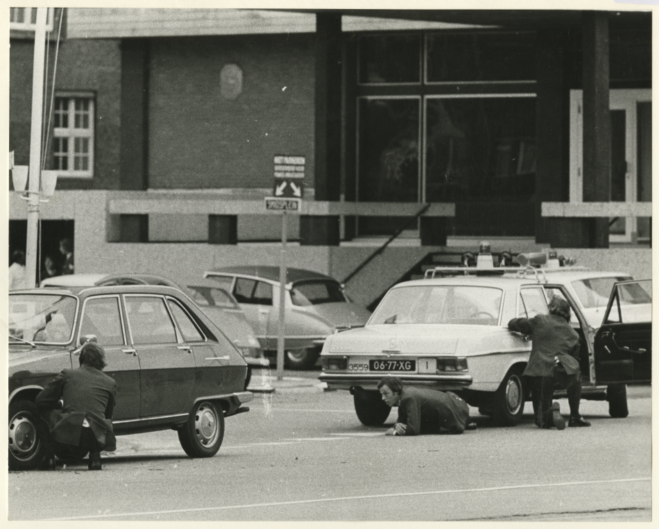 Scherpschutters van de politie zoeken dekking achter auto's ,1974, maker Fotoburo Meyer