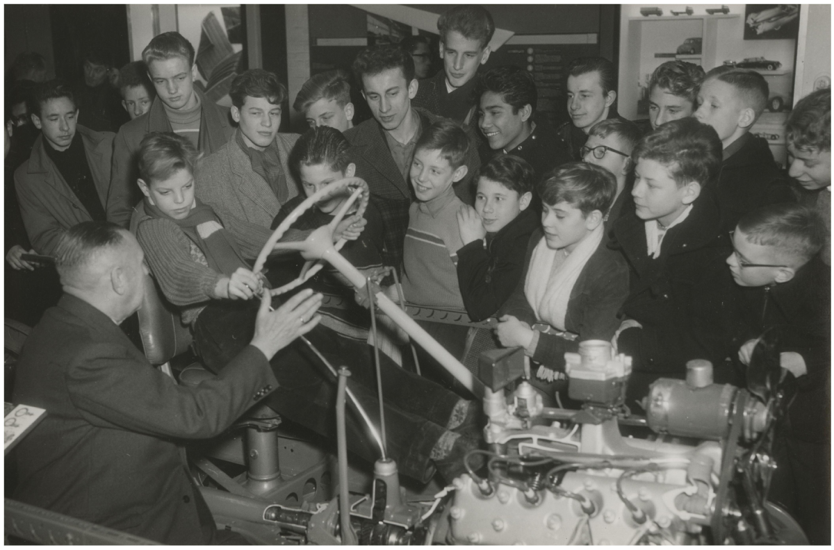Tentoonstelling De Auto in het Museum voor het Onderwijs; een klas van een Haagse ambachtschool krijgt onderricht over de bediening van een auto, 1959, maker Anefo Harry Pot